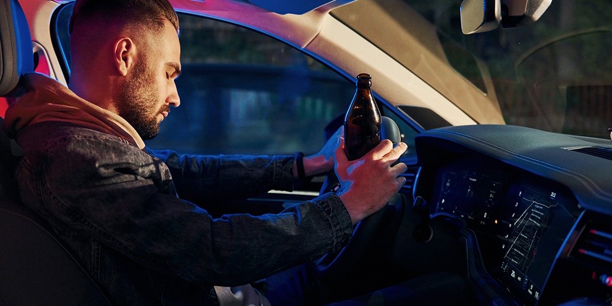 Blue and red police lights. Side view of unshaved drunk man in inside his automobile