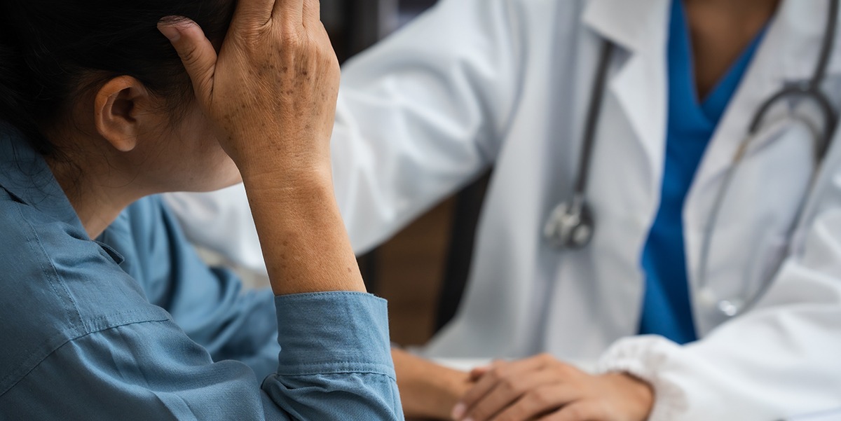woman being comforted by doctor after medical misdiagnosis