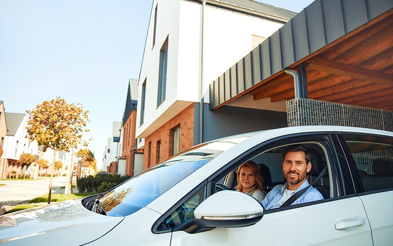 couple in car pulling out of driveway